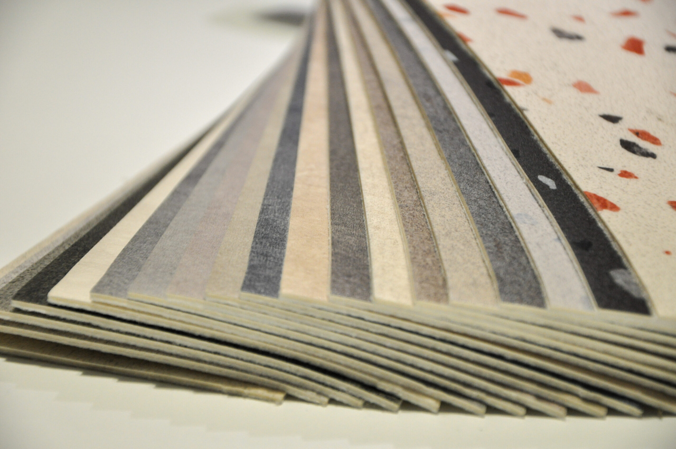 Découpe de sols en plastique et caoutchouc, présentant des échantillons avec motifs personnalisés pour nuancier de revêtements.