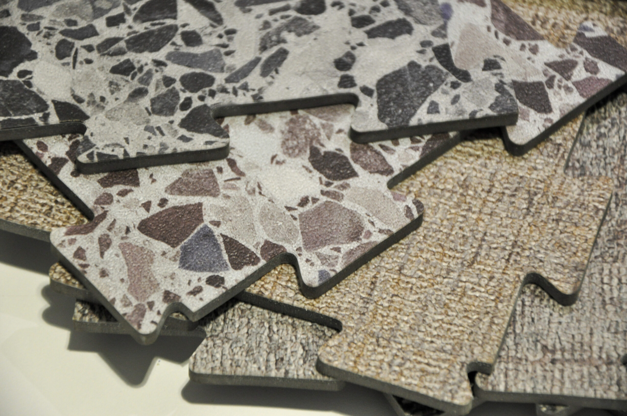 Découpe de dalles épaisses en forme de puzzle, offrant des revêtements de sols modulaires pour projets personnalisés et industriels.
